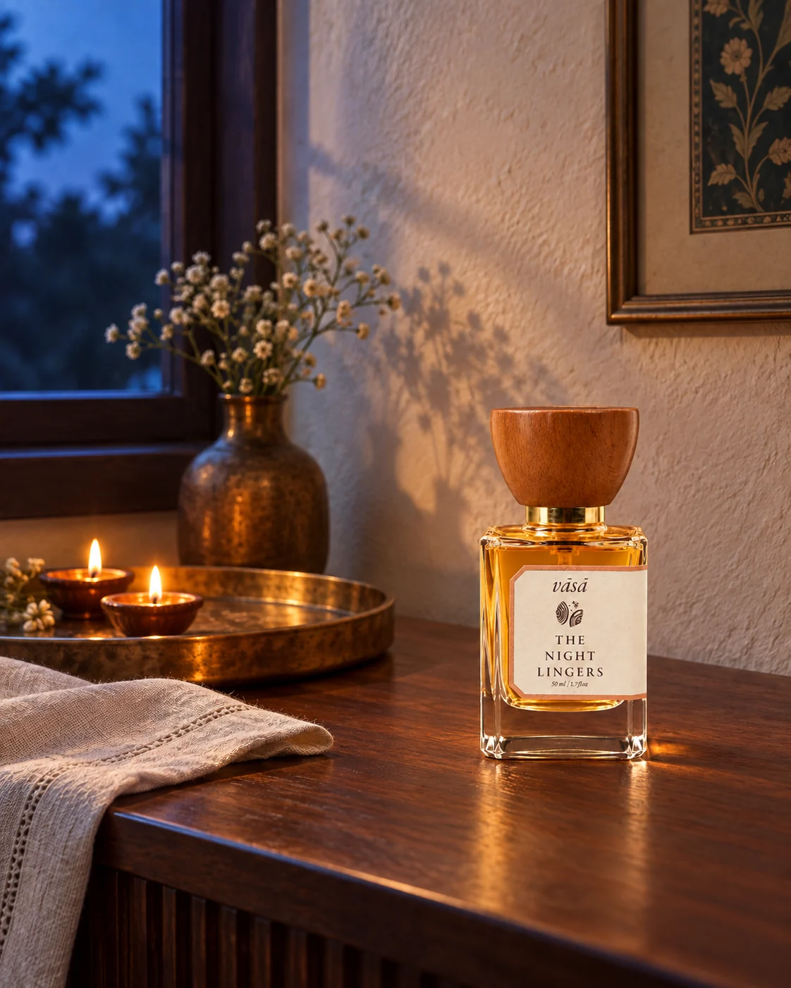 The Night Lingers fragrance in a warm, candlelit interior